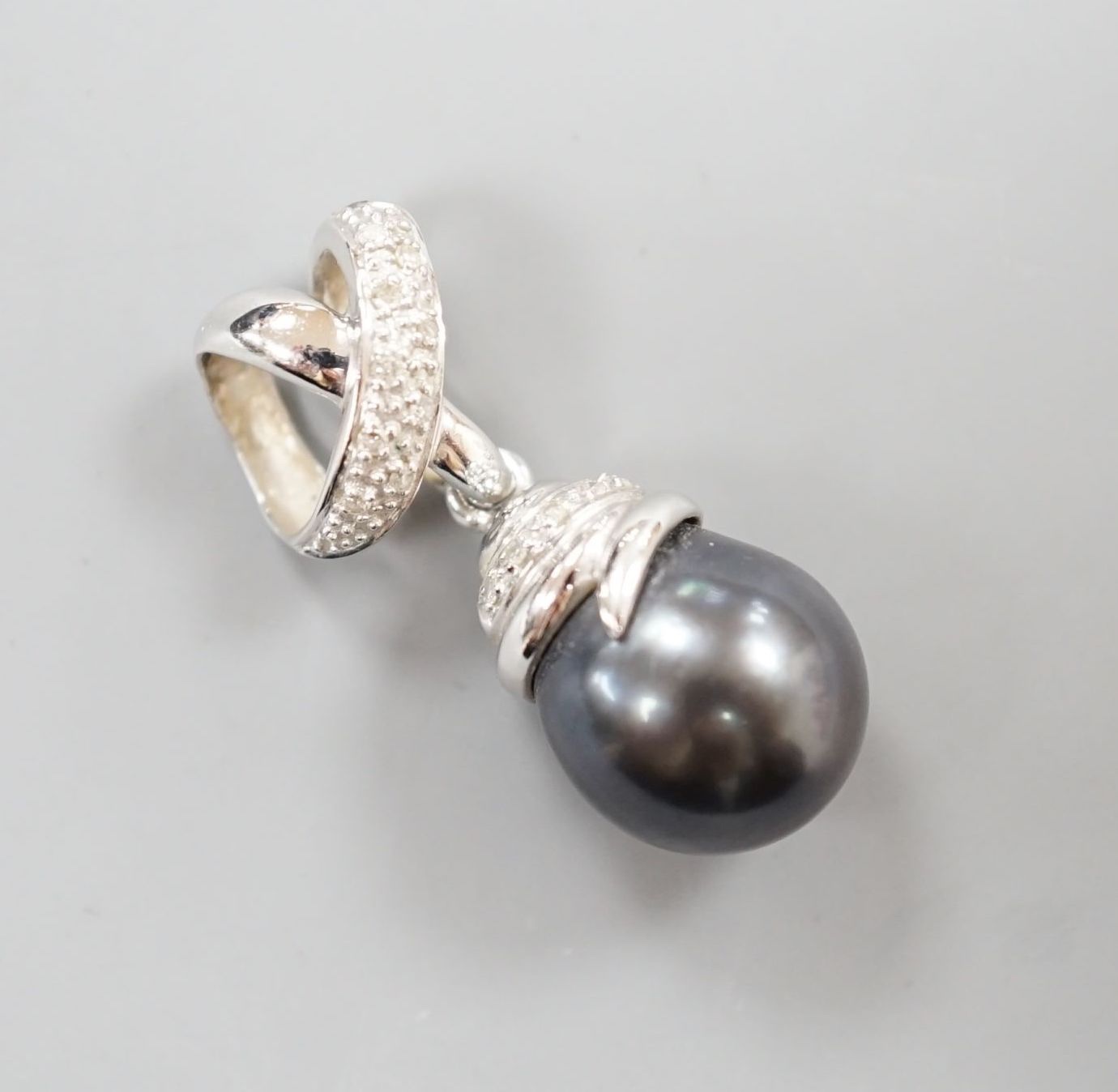 A modern 14k white metal, Tahitian cultured pearl and diamond chip set drop pendant, overall 30mm, gross weight 6.8 grams.